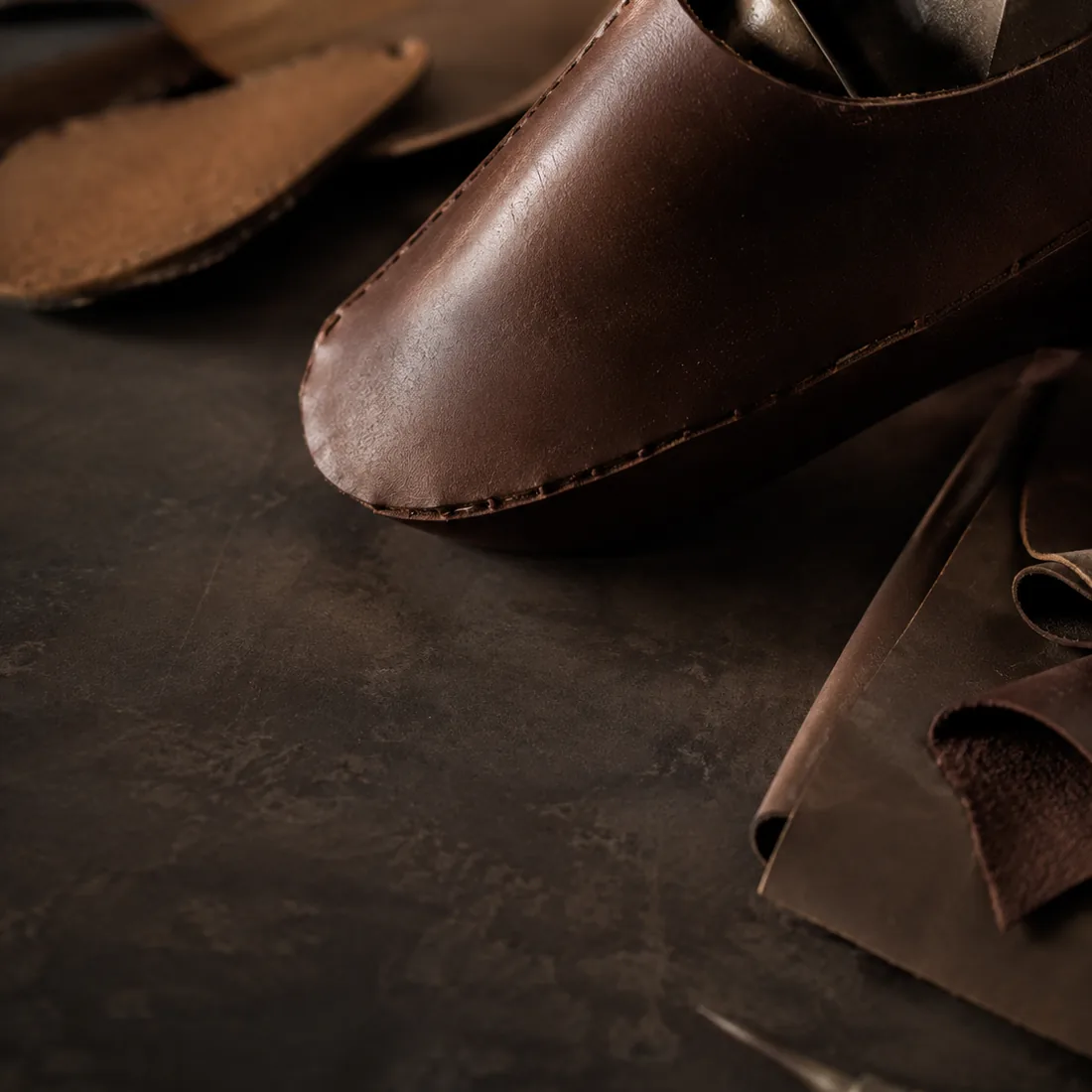 Anonymous leather footwear development detail on a workshop table